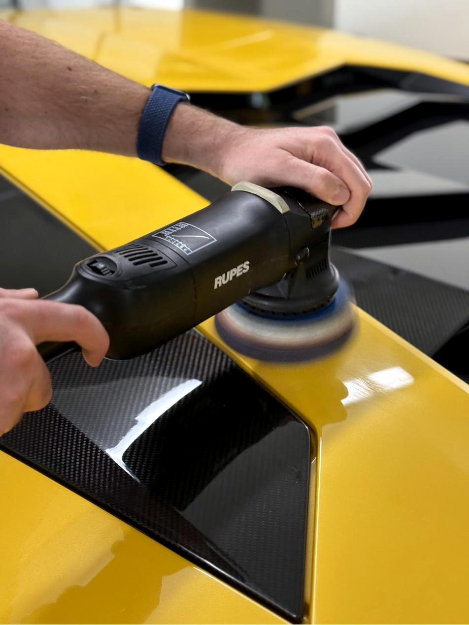 Poliermaschine in den Händen, Nahaufnahme auf gelbem Lamborghini
